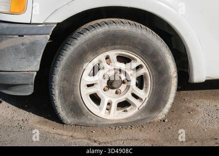 Reifenpanne auf weißem Auto. Stockfoto