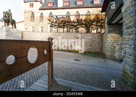 SOLINGEN, DEUTSCHLAND – 4. NOVEMBER 2025: Holzpranger und Ritterstatue im Innenhof des Burgmuseums in Solingen, Nordrhein-Westfalen Stockfoto