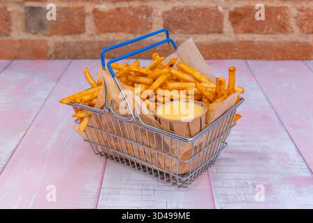 Klassisch geschnittene Pommes Frites sind lässig auf einem weißen Porzellanteller gestapelt, wobei auf jeder Seite verschiedene Goldtöne zu sehen sind Stockfoto