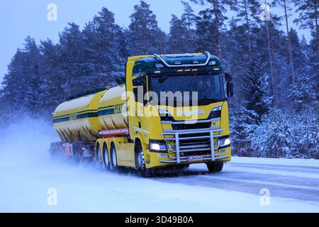Der farbenfrohe Tankwagen Scania R580 transportiert Güter auf verschneiten Straßen bei starkem Schneefall an einem Winterabend. Salo, Finnland. Januar 2019. Stockfoto
