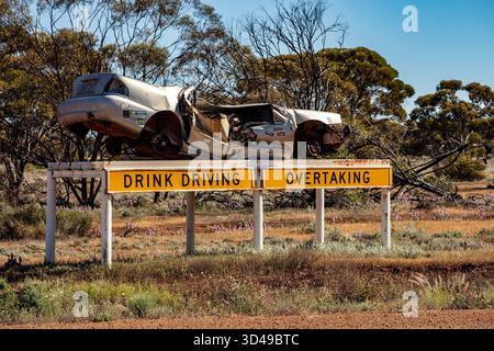 Die Polizei in Westaustralien kreatives Trinken beim Autofahren, Aufklärung zur Unfallverhütung von Unfallunfällen entlang der Straße, Landschaft dahinter. Überzeugend Stockfoto