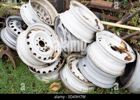 Alte Autofelgen mit Rost und Schmutz in einem Metallschrott. Konzept für industrielles Recycling, Abfallmanagement und Wiederverwendung von Autoteilen. Stockfoto