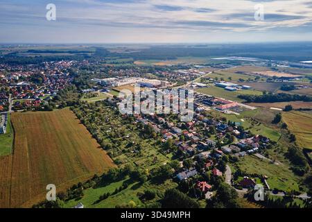 Aus der Vogelperspektive auf das Vorstadtviertel mit Wohnhäusern, Industriegebäuden und Ackerland rund um die Stadt. Konzept der Stadtentwicklung und Infrastruktur Stockfoto