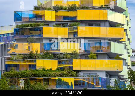 Modernes Wohngebäude mit farbenfrohen Balkonen und grünen Terrassengärten Stockfoto