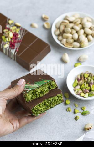 Essen, köstliche Pistazien und Kataifi Dubai Schokoladenriegel in Frauenhänden Stockfoto