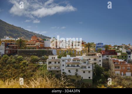 Wunderschöne kleine Stadt am Hügel auf Teneriffa, mit farbenfrohen Gebäuden mit Flachdächern. Das Bild fängt den lebendigen Charme und die vielfältige Architektur ein Stockfoto