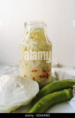 Hausgemachter, fermentierter Kohl mit Gewürzen, heißer Chili-Pfeffer, im Glas, Gärungsprozess, gesalzener Sauerkohl, Snack Stockfoto