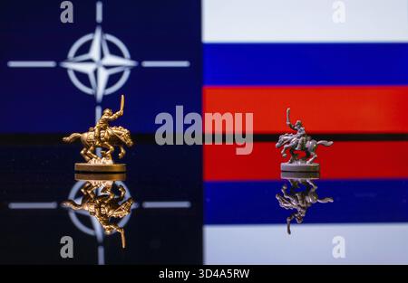 Konzeptuelles Bild des Krieges zwischen Russland und der NATO mit Spielzeugsoldaten und Nationalflaggen auf einem reflektierenden Hintergrund Stockfoto