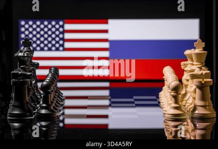 Konzeptuelles Bild des Krieges zwischen den Vereinigten Staaten und Russland mit Schachfiguren und Nationalflaggen auf einem reflektierenden Hintergrund Stockfoto