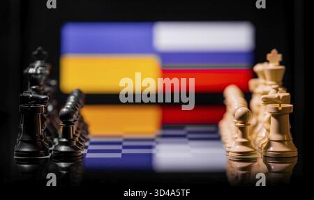 Konzeptuelles Bild des Krieges zwischen Russland und der Ukraine mit Schachfiguren und Nationalflaggen auf einem reflektierenden Hintergrund Stockfoto