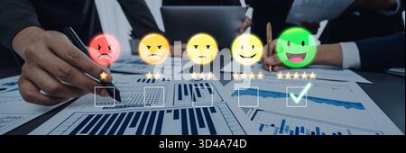 Experten analysieren die Kundenzufriedenheit anhand visueller Rückmeldungen mithilfe von Smiley-Gesichtern und statistischen Diagrammen in einer gemeinsamen Büroumgebung Stockfoto