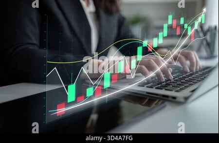 Ein Geschäftsmann arbeitet mit einem Notebook, analysiert komplexe Börsendiagramme und zeigt Trends in einer Büroumgebung an. Anmahnen Stockfoto