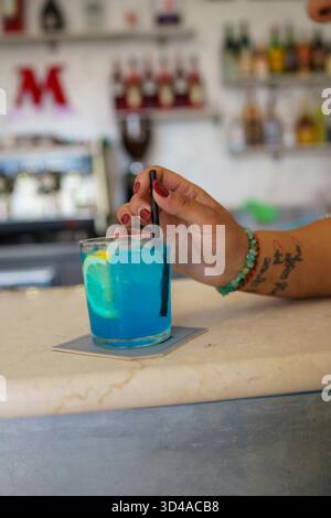 Crema, Italien - 25. August 2025 erfrischender Blauer Cocktail mit Zitronengarne, serviert an einer stilvollen Bar mit subtilem künstlerischem Flair Stockfoto