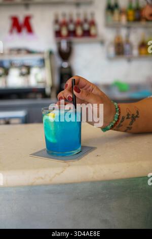 Crema, Italien - 25. August 2025 erfrischender blauer Cocktail mit Garnish auf einer strukturierten Arbeitsplatte Stockfoto
