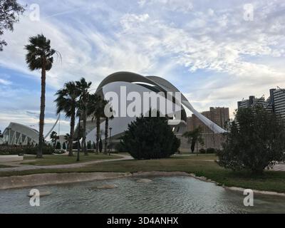 Valencia, Spanien - 31. Dezember 2017: Futuristische Architektur des Palau de les Arts Reina Sofia in Valencia, umgeben von Palmen und Wasser Stockfoto
