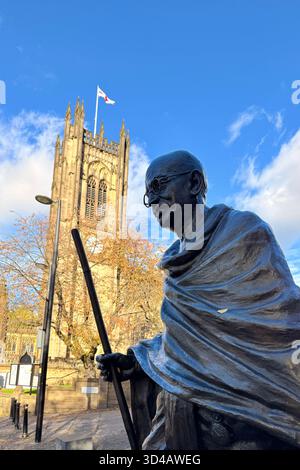 Statue von Mahatma Gandhi mit der Kathedrale von Manchester im Hintergrund im Stadtzentrum von Manchester Stockfoto