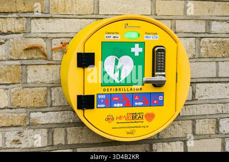 Woodstock, Oxfordshire, England, Vereinigtes Königreich - 8. Oktober 2025: Automatischer AED-Defibrillator für den öffentlichen Gebrauch im Notfall an der Wand eines Ladens Stockfoto