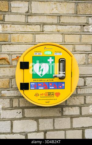 Woodstock, Oxfordshire, England, Vereinigtes Königreich - 8. Oktober 2025: Automatischer AED-Defibrillator für den öffentlichen Gebrauch im Notfall an der Wand eines Ladens Stockfoto