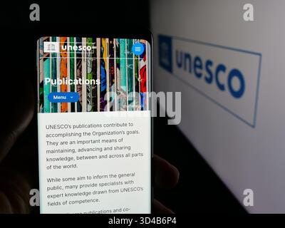 Stuttgart, Deutschland - 10-31-2025: Person, die ein Mobiltelefon hält, auf dem Bildschirm vor dem Logo die Webseite der UNESCO-Organisation der Vereinten Nationen angezeigt wird. Stockfoto