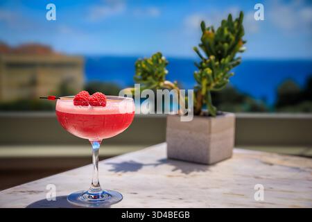 Champagner-Cocktail mit Himbeer in einem Dachrestaurant mit Blick auf das Mittelmeer und die Altstadt oder Vieille Ville in Nizza, Frankreich Stockfoto