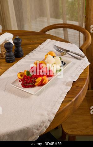 Ein wunderschön gestalteter frisch geschnittener Obstteller auf einem rustikalen Holztisch Stockfoto