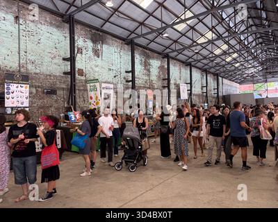 Carriageworks Farmers Market, ein Indoor-Markt in Sydney, Australien, der von zahlreichen Käufern besucht wird, die unter einem Wellpappenboden Lebensmittel- und Kunsthandwerksstände erkunden Stockfoto