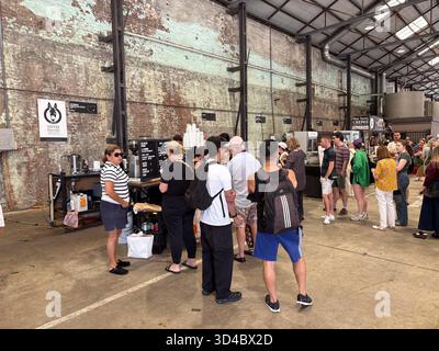 Carriageworks Farmers Market in Sydney, Australien, bietet eine geschäftige Menschenmenge um einen Kaffeestand in einem Industriekonzern mit Backsteingebäude Stockfoto