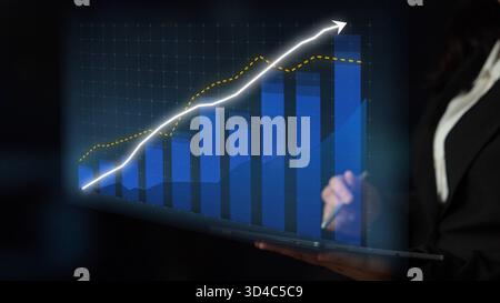 Ein Geschäftsexperte analysiert einen Laptop-Bildschirm, der ein Wachstumsdiagramm mit blauen und gelben Trends anzeigt, das eine positive finanzielle Performance und symbolisiert Stockfoto