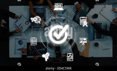 Ein Geschäftsteam arbeitet an der strategischen Planung rund um einen Tisch, zeigt Diagramme und Diagramme an, um die Zusammenarbeit und den Erfolg eines Profis hervorzuheben Stockfoto
