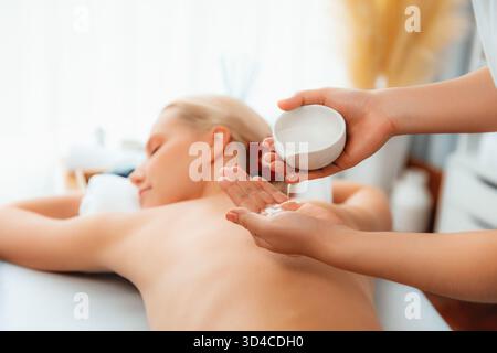 Masseurhände gießen Aromaöl auf den Rücken der Frau. Masseurin bereitet im Spa-Salon im Luxusresort eine Ölmassage für den Kunden vor. Aromaölkörper Stockfoto