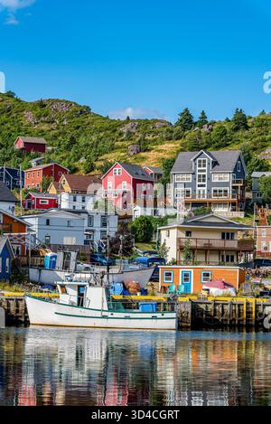 Petty Harbour, NL, Kanada – 9. August 2024: Kanadische Flaggen fliegen über Booten und Fischern in Petty Harbour, Neufundland Stockfoto
