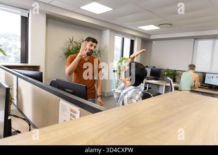 Viele männliche Kollegen feiern Projektgewinn im Großraumbüro, mit Monitor und Kopierraum Stockfoto