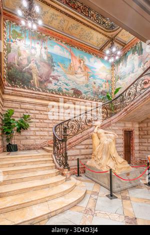 Großer Blick auf die große Marmortreppe, die klassische Statue und die große mythologische Decke und Wandmalerei im Hotel Pams, Perpignan, Frankreich Stockfoto