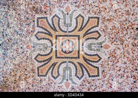 Detail des reich verzierten Terrazzo- oder Mosaikfußbodens mit einem zentralen geometrischen Blumenmuster im Hotel Pams, Perpignan, Frankreich Stockfoto