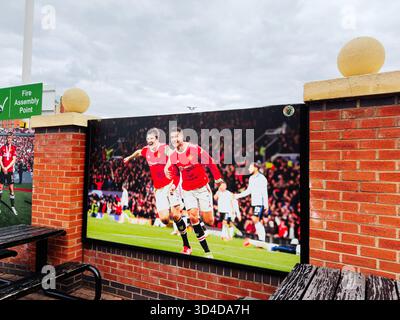 Manchester, UK - September 30, 2025: Football stars celebrate on a big outdoor screen in Manchester, UK, amid a cheering crowd. Stockfoto