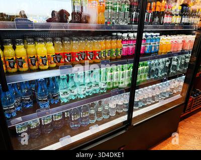 Nowy Dwor Mazowiecki, Polen - 22. Oktober 2025: Verschiedene Getränke in Flaschen stehen hinter einem Glaskühlschrank in einem 24-Stunden-Geschäft am Flughafen. Stockfoto