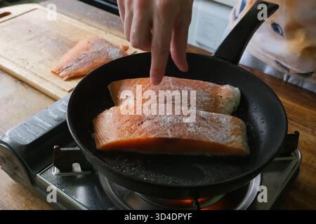 Braten Sie roten Fisch in einer Pfanne. Stücke von roten Fischen. Stockfoto