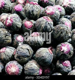 Istanbul, Türkiye - 8. November 2025: Nahaufnahme einer großen Ausstellung von handgebundenen blühenden Teebugeln, bestehend aus getrockneten Camellia sinensis Blättern und Gomphrena Stockfoto