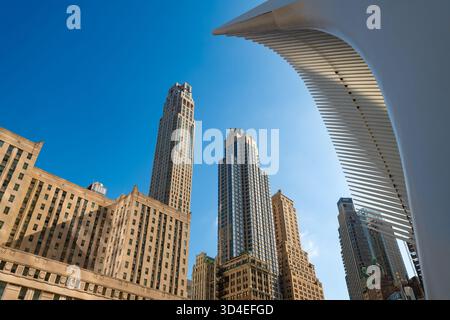 Ein wunderschöner Blick auf die Skyline von Downtown Manhattan, mit klassischen Hochhäusern und der avantgardistischen Architektur des Oculus unter einem klaren blauen Himmel Stockfoto