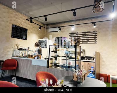 Kiew, Ukraine - 10. November 2025: Eine einladende Coffee-Shop-Szene mit Theke, Glasgebäckkasten, Tafel-Menü und gemütlichen Sitzbereichen. Stockfoto