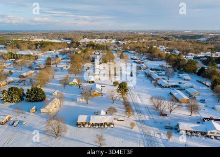 Vorstadtgebiet mit Schnee bedeckt, amerikanisches Dorf, das an klaren Wintertagen die Bäume der Häuser hervorhebt Stockfoto