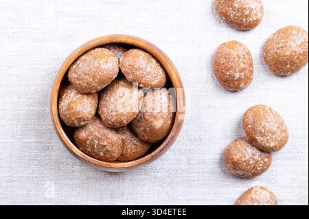 Lebkuchenkekse, zuckerglasierte Weihnachtskekse, in einer Holzschale, auf Leinen. Gewürzkekse. Stockfoto