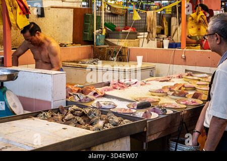 Fischhändler, der Fisch hinter einem Fischstand für den Verkauf auf dem Indoor Fish Market in Little China, Singapur, am 27. Oktober 2013 zubereitet Stockfoto