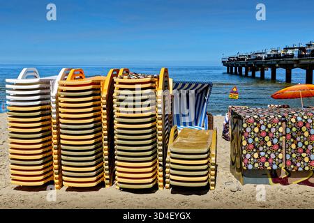Am Sandstrand liegen und gestreifte Unterstände. Stockfoto