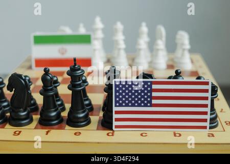 Die Flagge der USA und eine iranische Flagge auf dem Schachbrett. Konflikt zwischen diesen beiden Ländern. Stockfoto