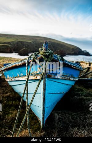 Ein heruntergekommenes Boot an der Küste mit einem Seil, das von vorne kommt Stockfoto