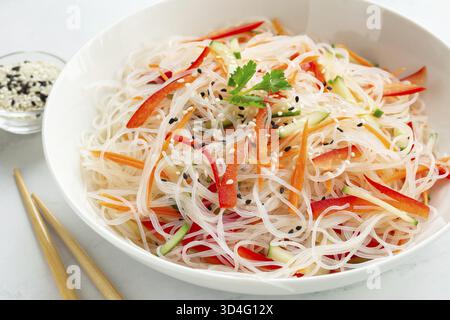 Essen, Nahaufnahme von Funchoza-Reisnudeln und Gemüsesalat in einer weißen Schüssel Stockfoto