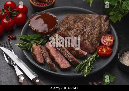 Essen, in Scheiben geschnittene, mittelseltene Ribeye-Steaks, schwarzer Hintergrund, Kopierraum Stockfoto
