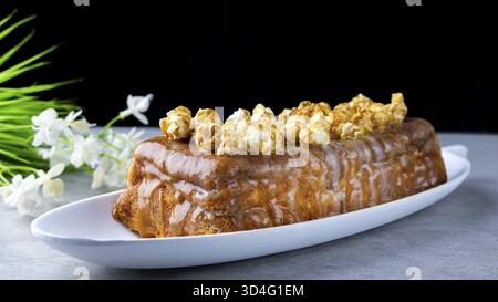 Essen, Hüttenkäse-Auflauf mit Rosinen und Karamell-Popcorn, mit Karamell-Sauce begossen Stockfoto