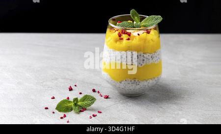Essen, Mango Chia Pudding im Glas. Ein ausgezeichnetes gesundes veganes Dessert mit Chiasamen. Mango- und Kokosmilch Stockfoto